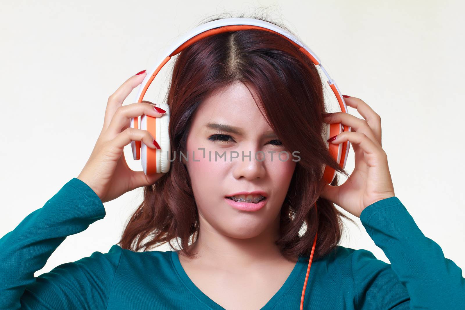 portrait of beautiful young woman with earphones listening a bad music noise