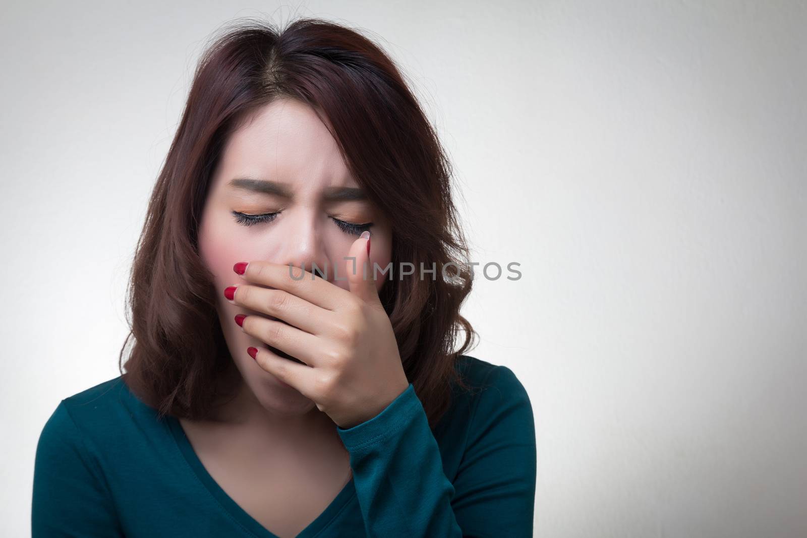 beautiful asian young woman placing hand covering mouth yawning