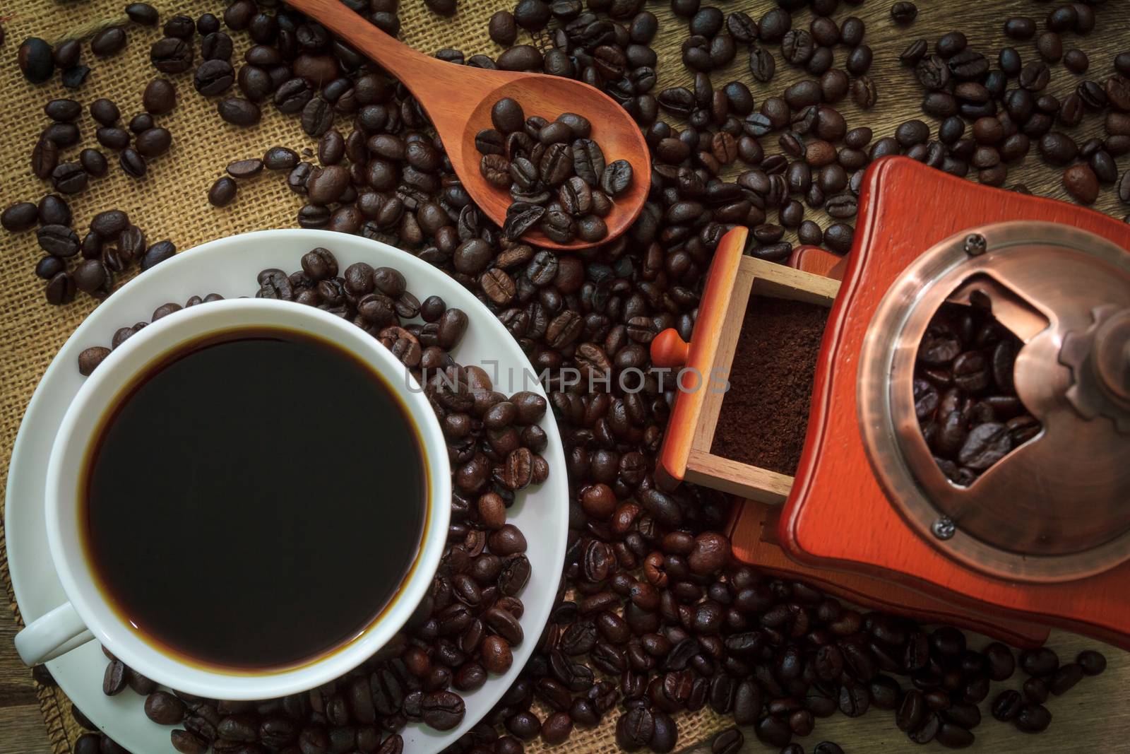 Hot Coffee in cup and coffee grinder on a wooden table