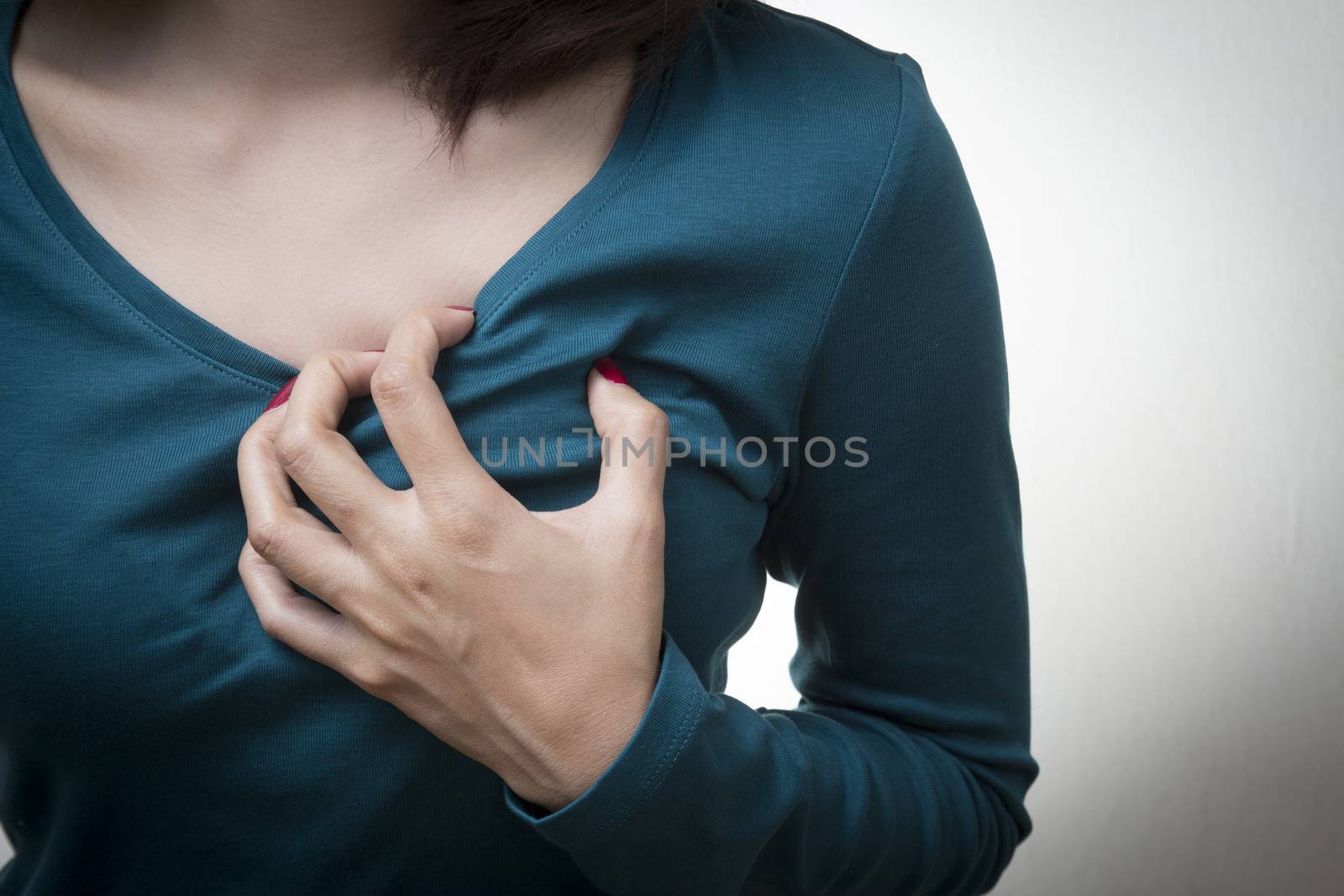 Woman is clutching her chest, acute pain possible heart attack