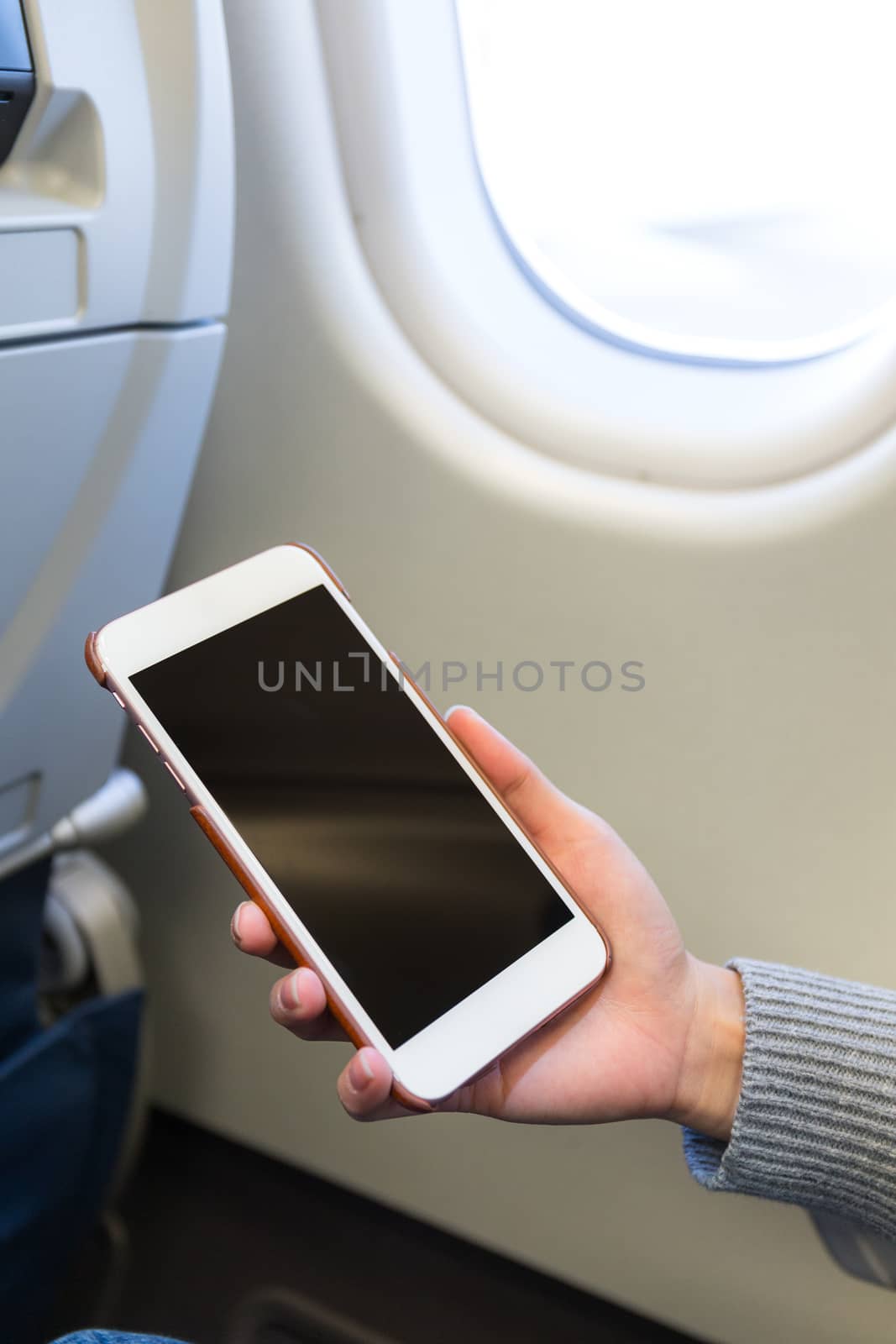 Woman use of smartphone inside airplane
