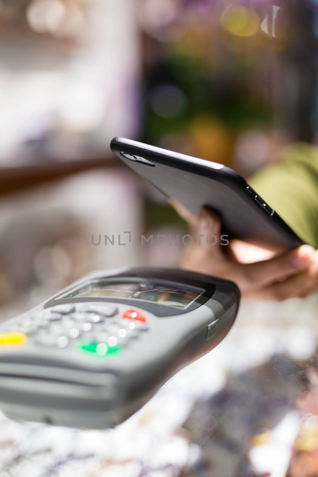 Woman paying with NFC technology on celphone