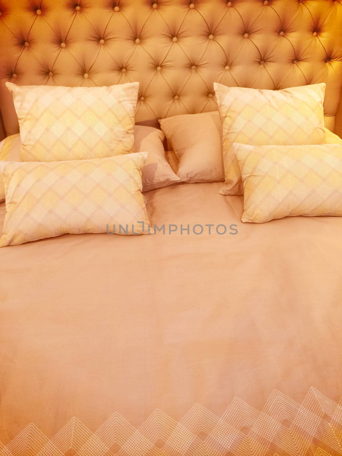 Luxurious bed with silky linen and lots of pillows.