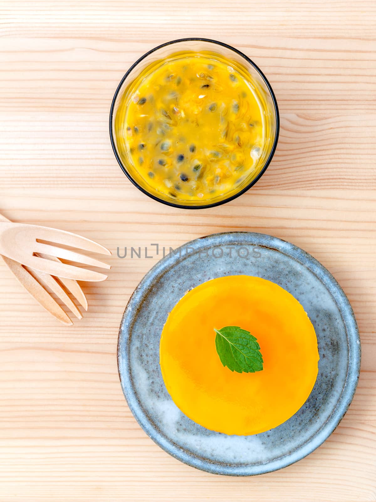 Passion fruit cheesecake with fresh mint leaves on wooden background. Passion fruit cheesecake setup with Passion fruit juice and fresh Passion fruit .Selective focus depth of field.