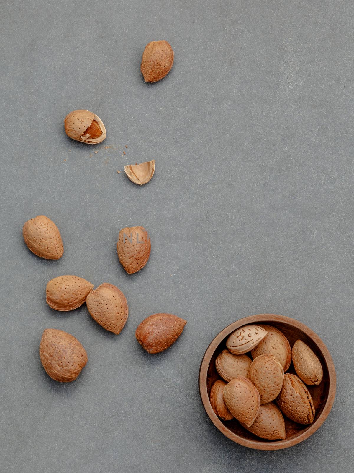 Almonds kernels and whole almonds on concrete background. Whole and chopped almond on concrete background. 