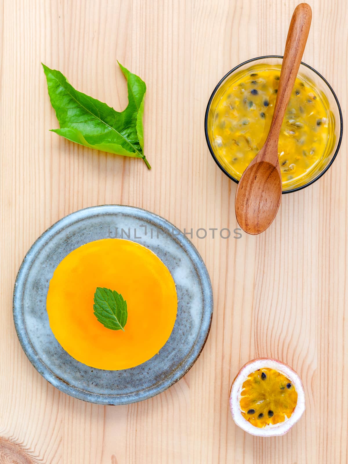 Passion fruit cheesecake with fresh mint leaves on wooden background. Passion fruit cheesecake setup with Passion fruit juice and fresh Passion fruit .Selective focus depth of field.