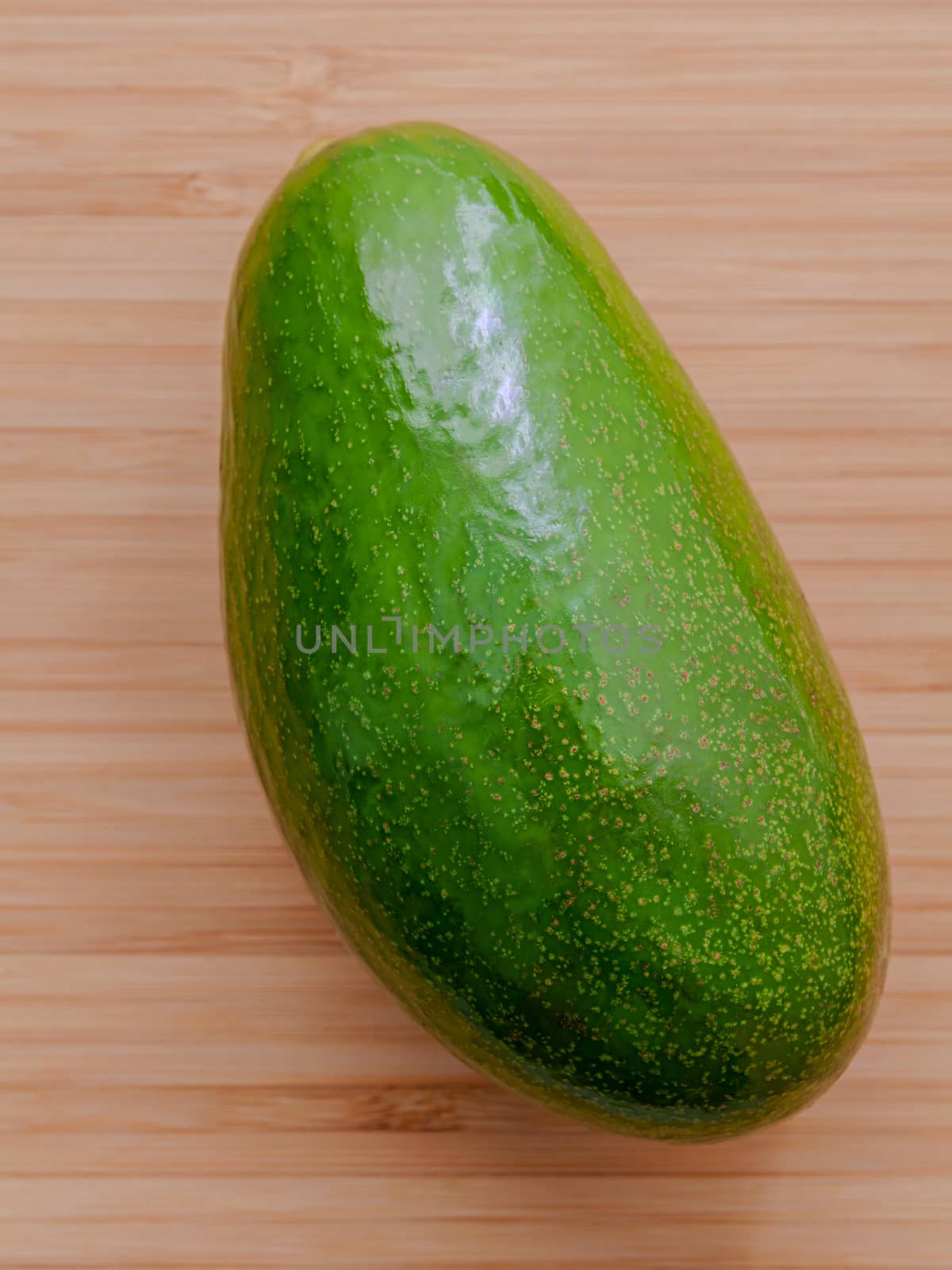 Fresh avocado on wooden background. Organic avocado healthy food concept.
 Avocado on Bamboo cutting board.The avocado is popular in vegetarian cuisine and weight control.