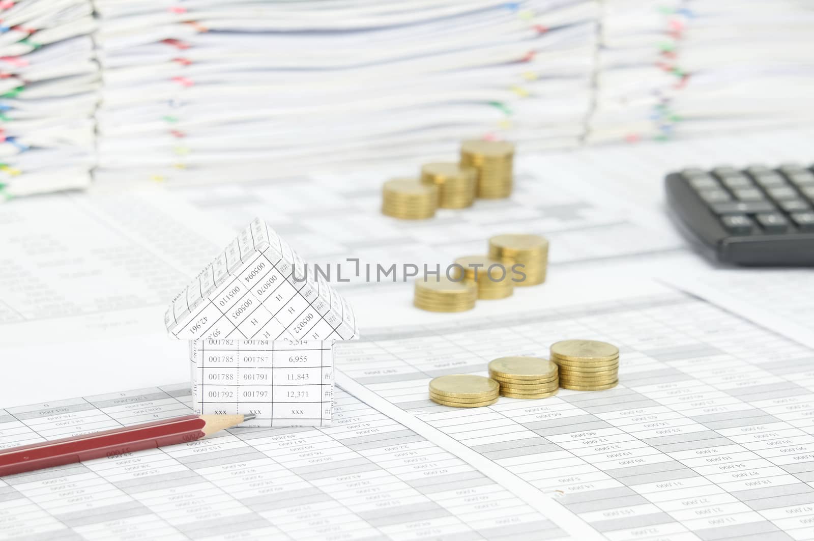 House and brown pencil on finance account have blur step pile of gold coins with calculator and overload of document with colorful paperclip as background.