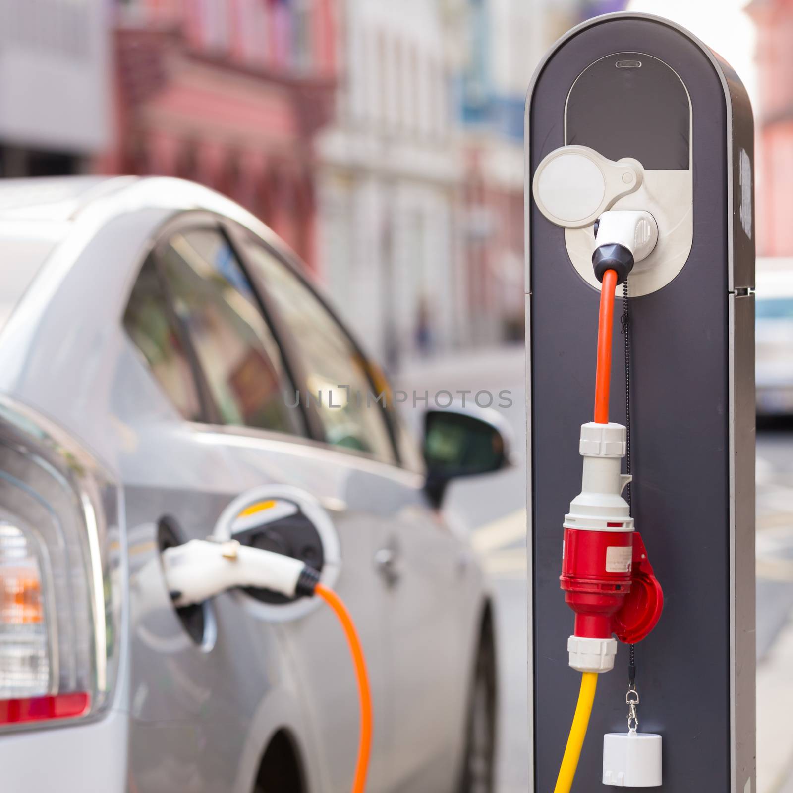 Power supply for electric car charging.  Electric car charging station. Close up of the power supply plugged into an electric car being charged.