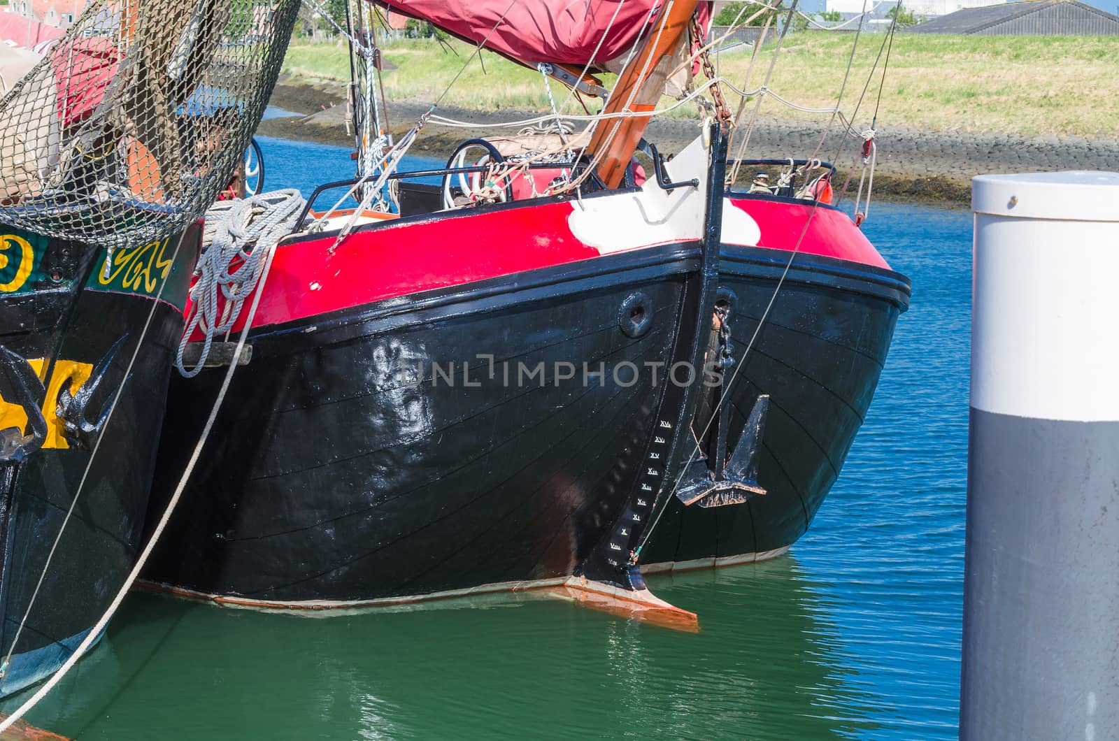 Close up of a ship's rail of an old wooden sailing boat. rope to a sailing mast.
