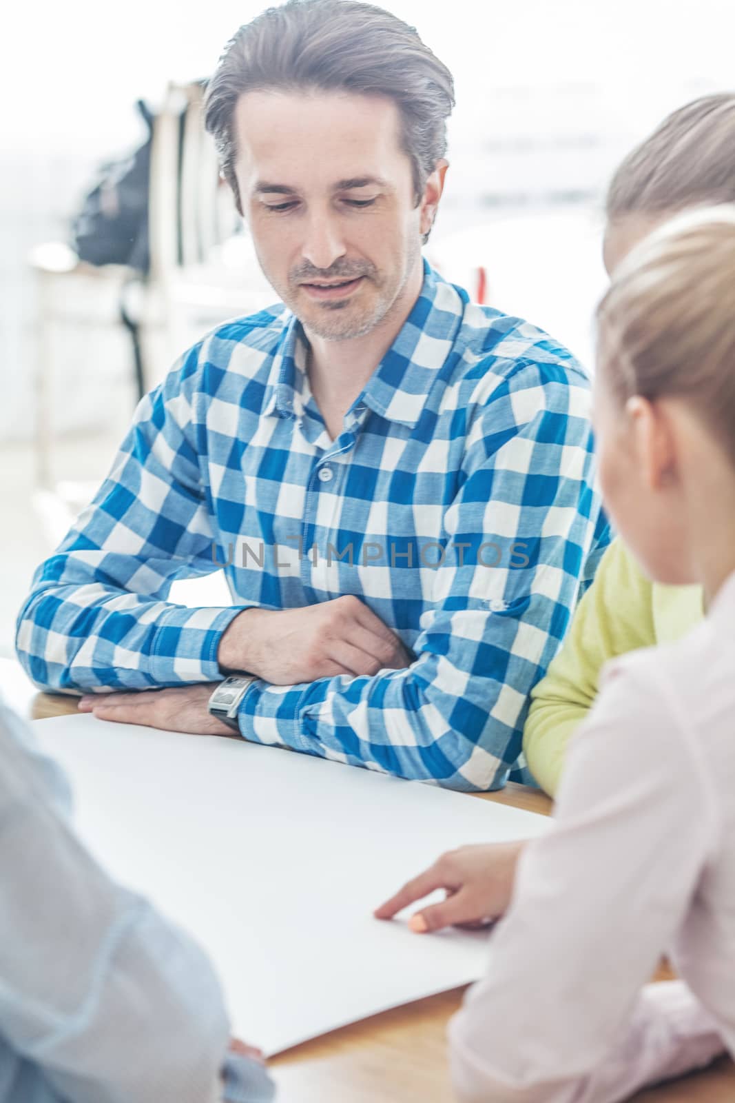 Business team talking at meeting table by ALotOfPeople