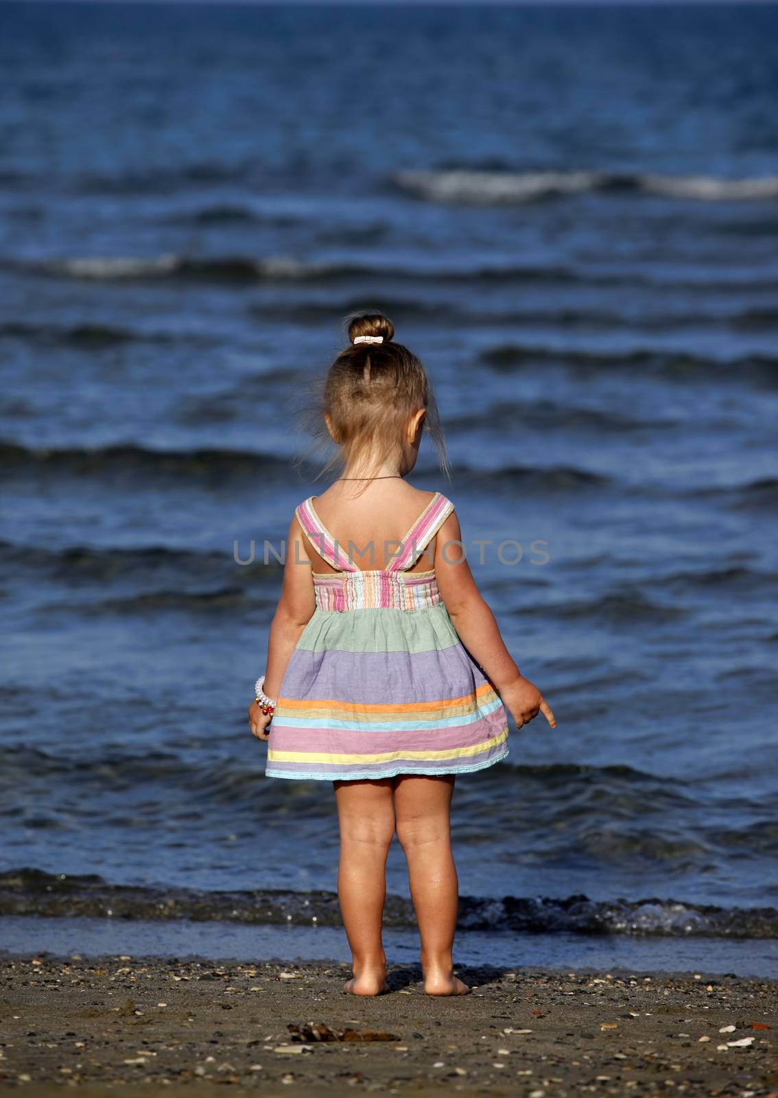 Small girl on the beach by friday