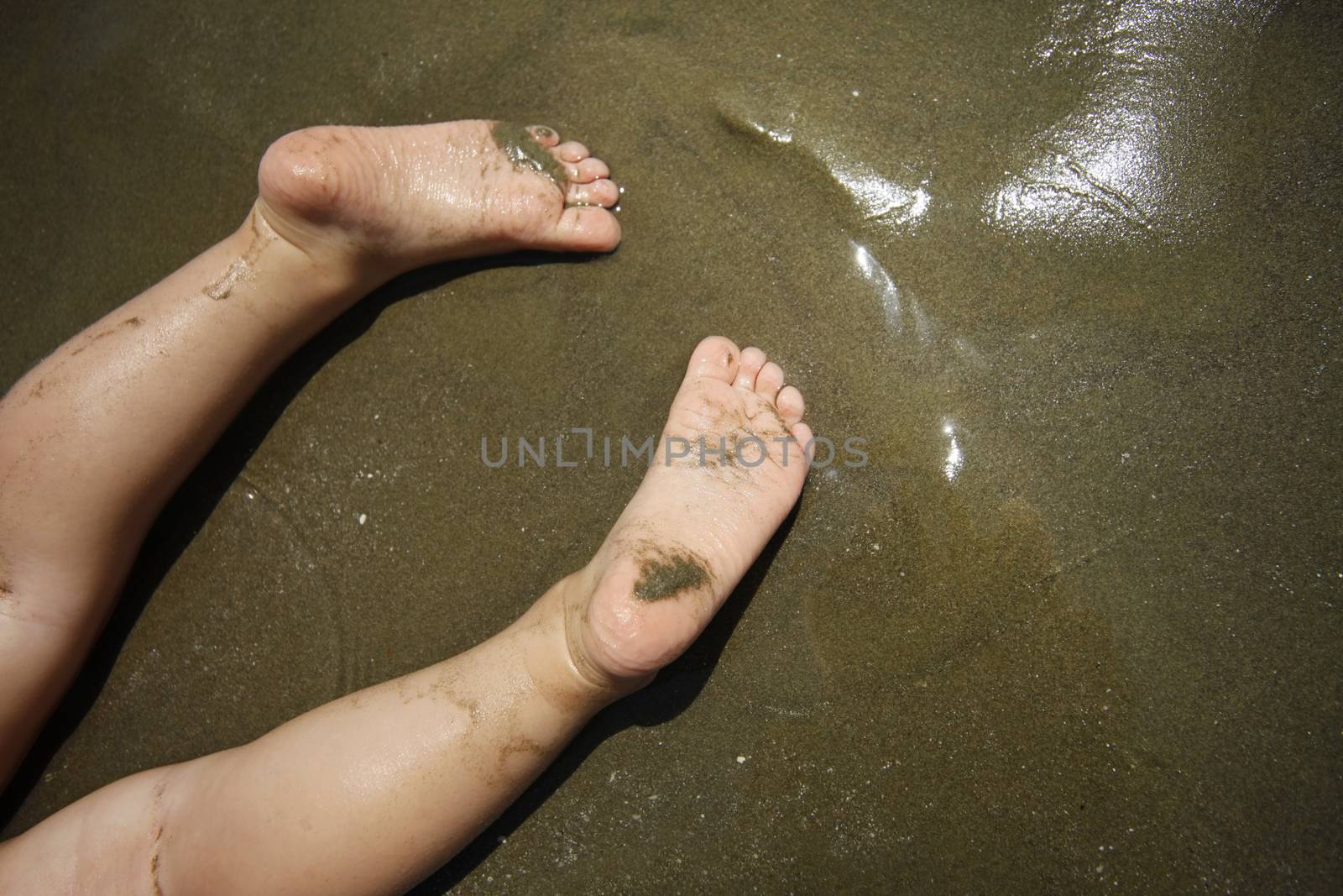 Baby feet on the beach. Summer beach background.