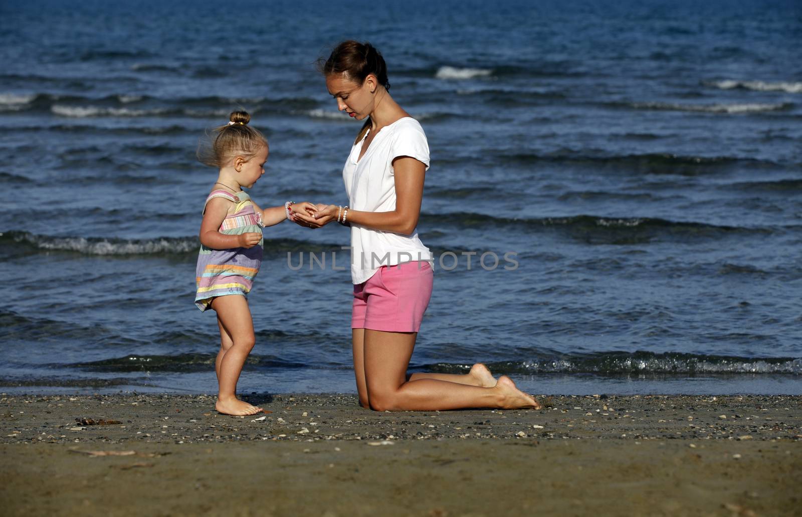 Happy mother holding her daughter on the beach