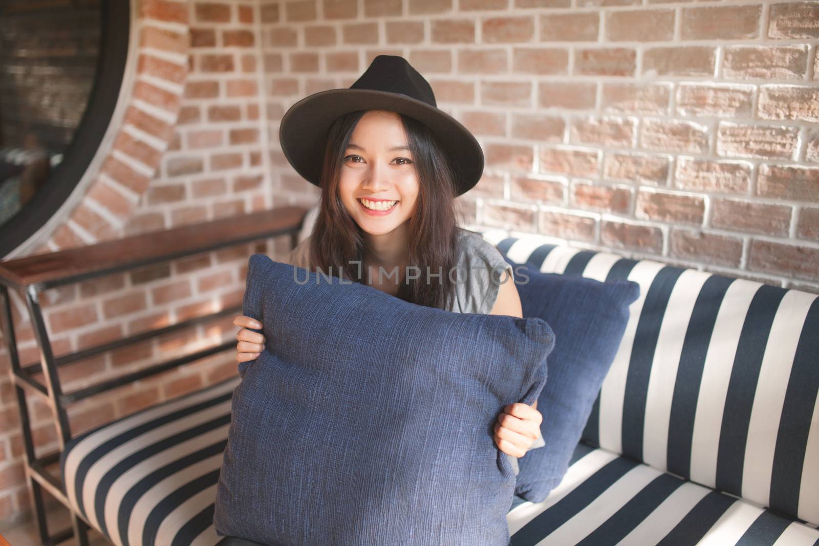 Woman smiling near rustic brick wall, Color process vintage style