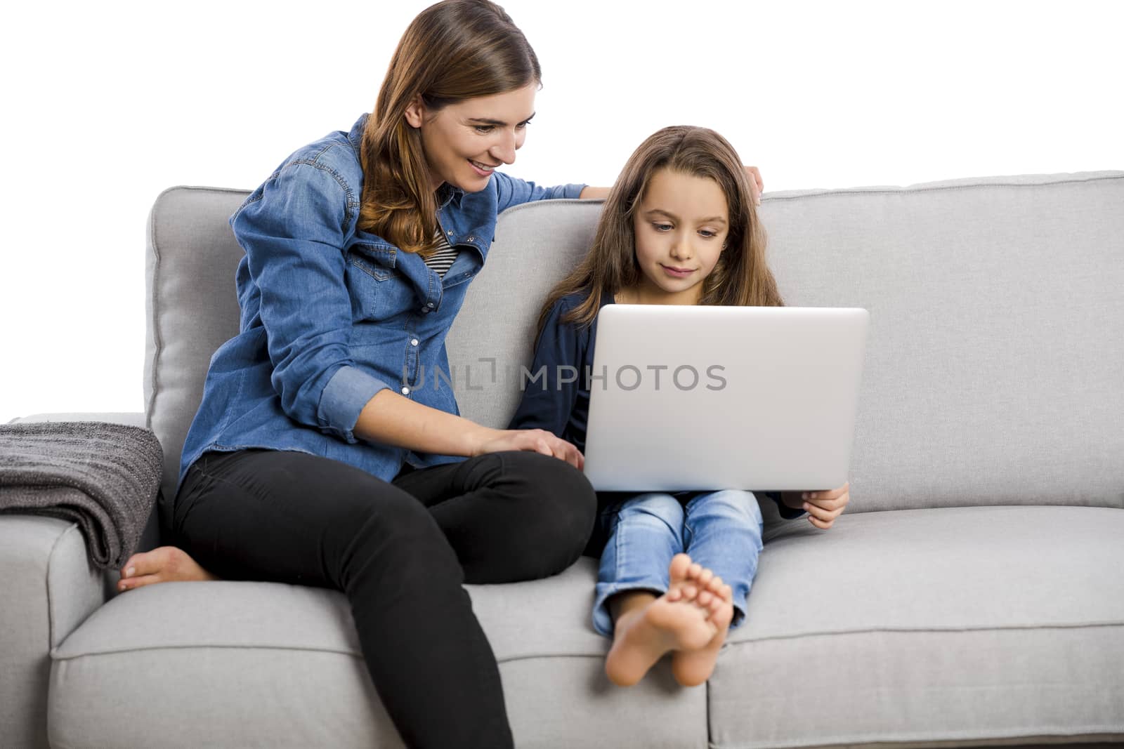 Mother teaching her little daughter working with a laptop