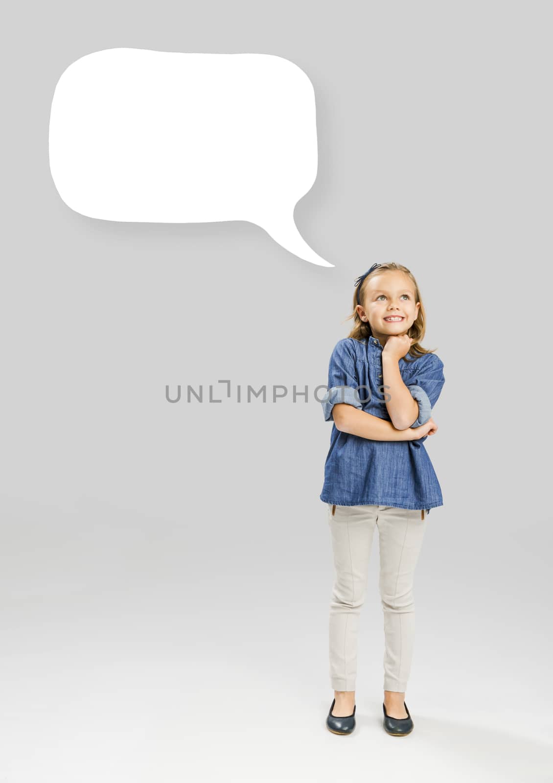 Beautiful little girl holding and showing a speech balloon