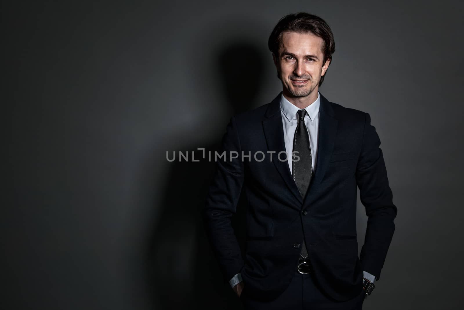 Portrait of businessman in suit on dark background