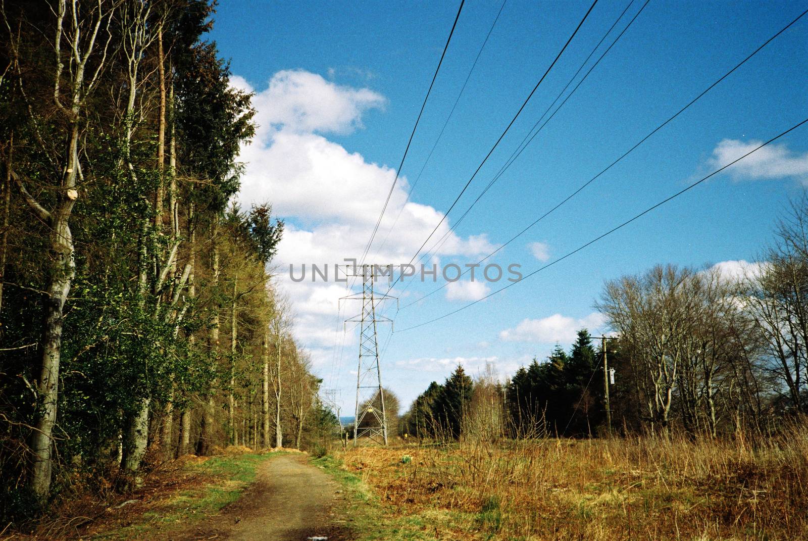 Film image of steel pylon with high voltage distribution powerlines in nature
