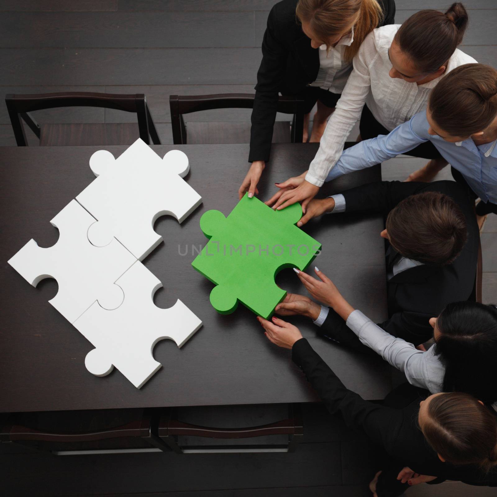 Business people assembling puzzle  by ALotOfPeople