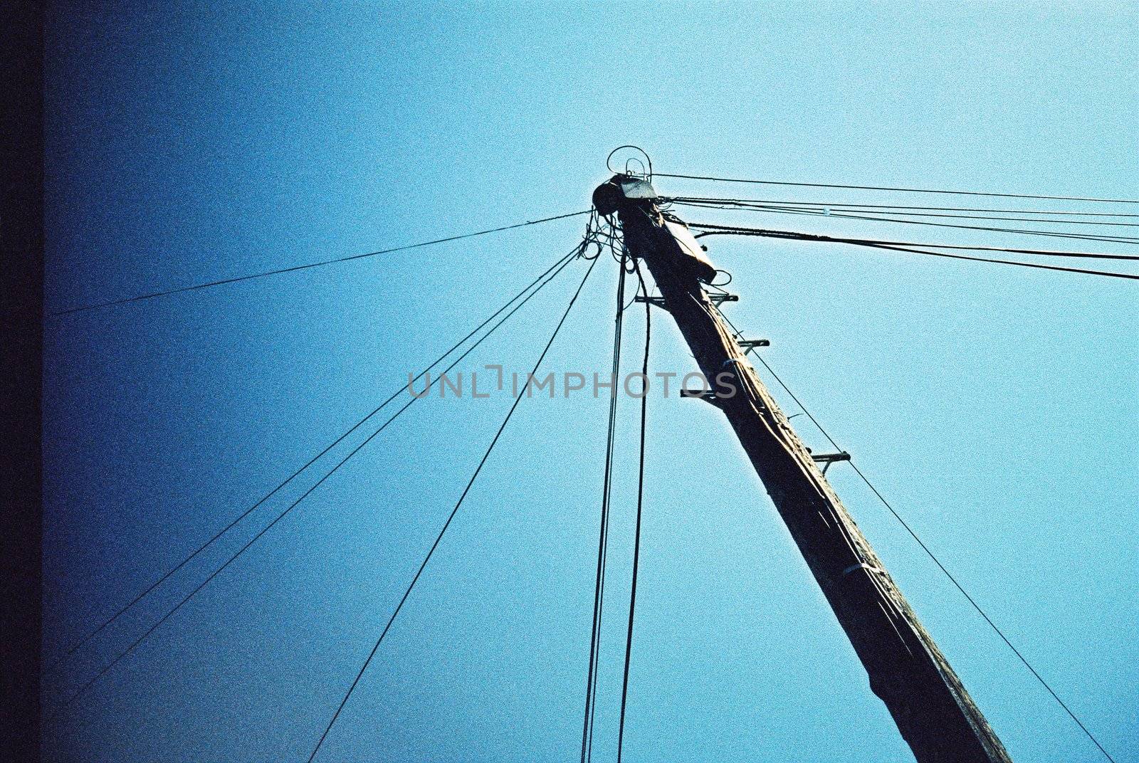 Wood electric pole power lines and wires with blue sky