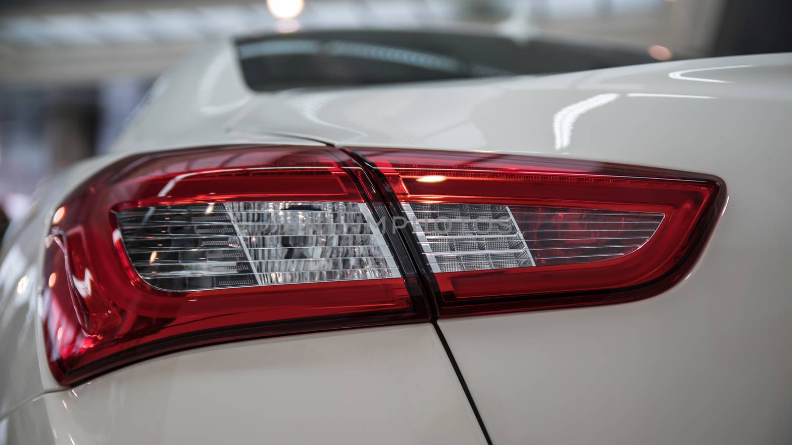 Detail on the rear light of a white car