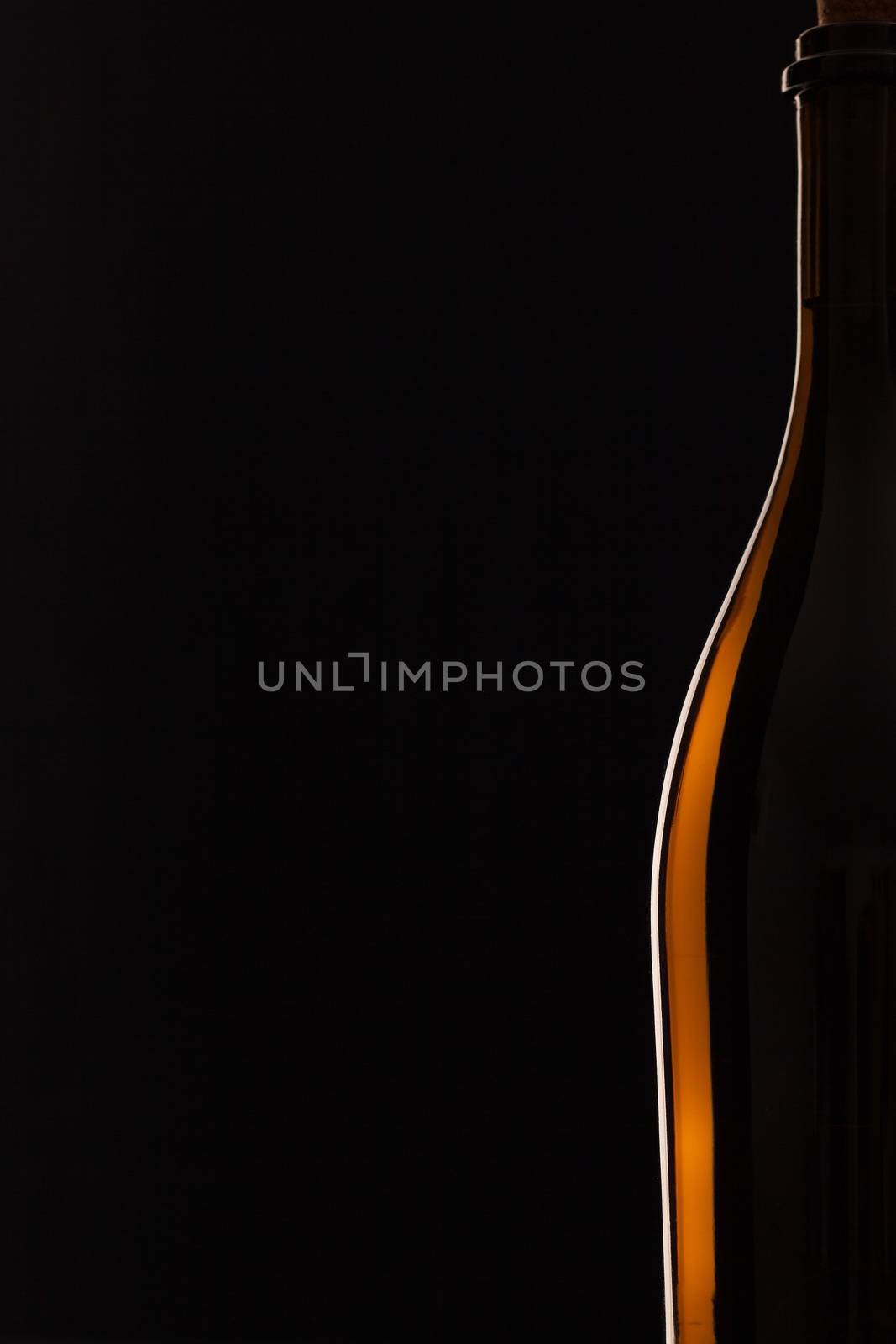 Detail of bottle with red wine on the black background