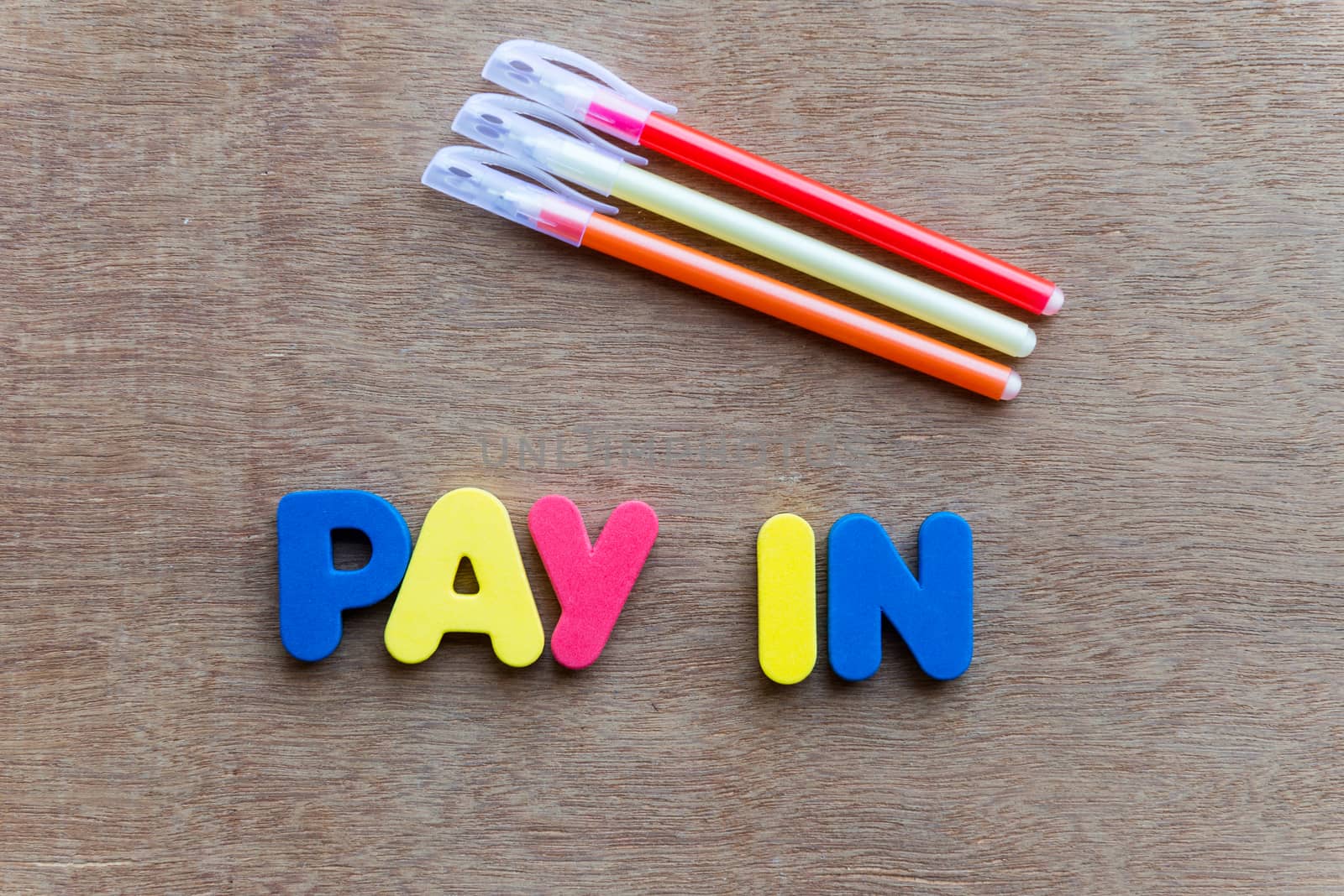 pay in colorful word on the wooden background