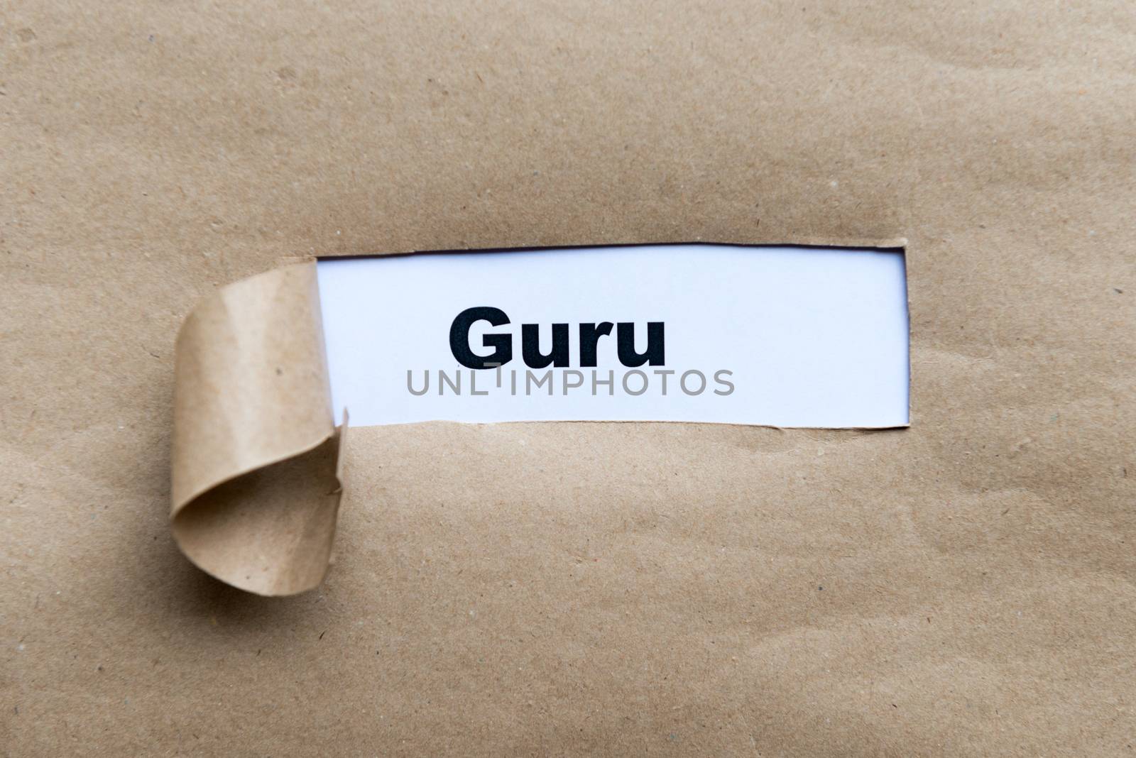 guru word on the torn paper background