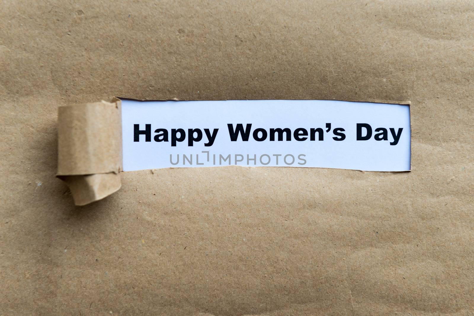 happy women's day word on the torn paper background