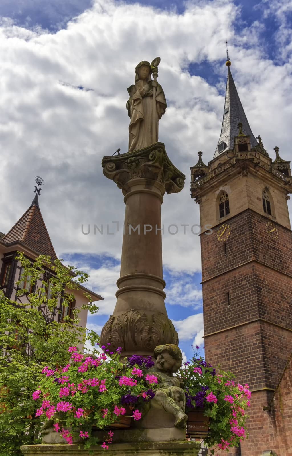 Sainte-Odile fountain and Kappelturm in Obernai village by day, Alsace, France