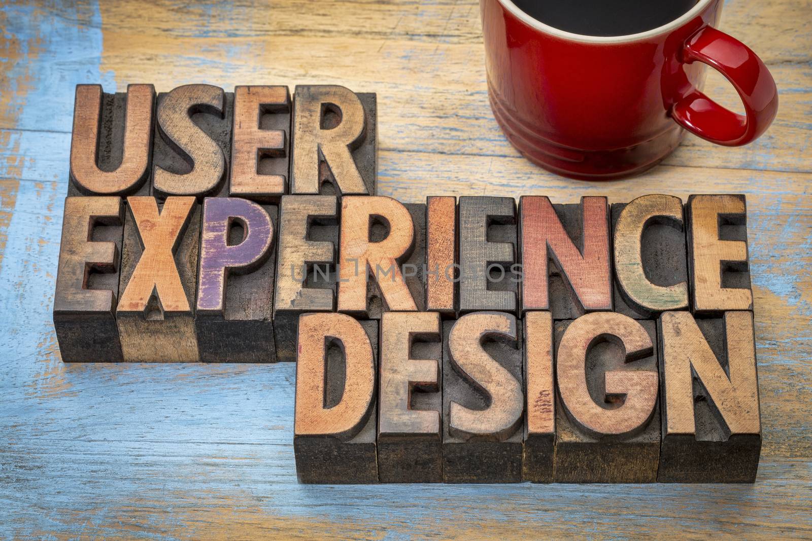 user experience design - word abstract in vintage letterpress wood type with a cup of coffee