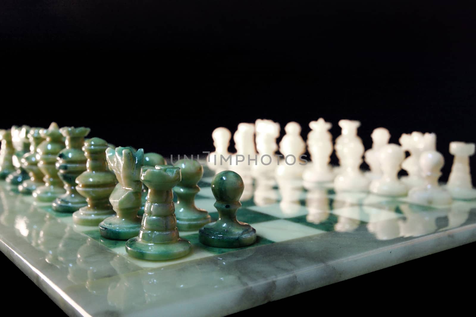 chessboard and alabaster chess on a black background