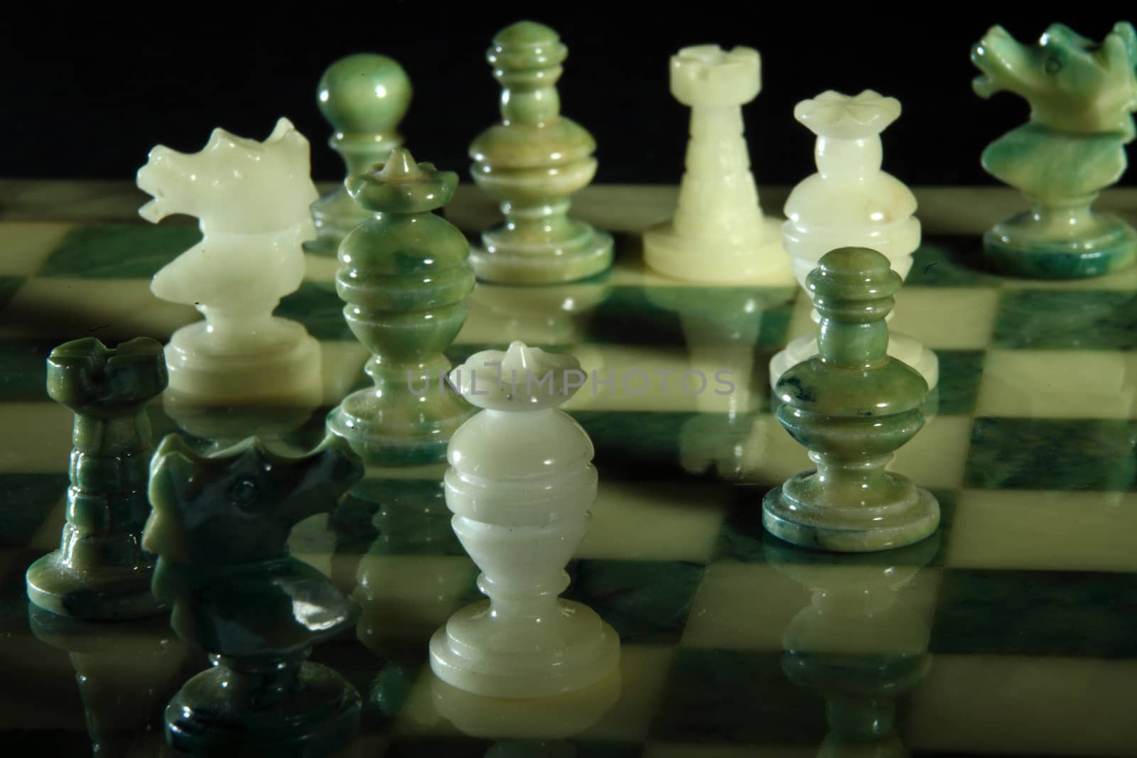 chessboard and alabaster chess on a black background