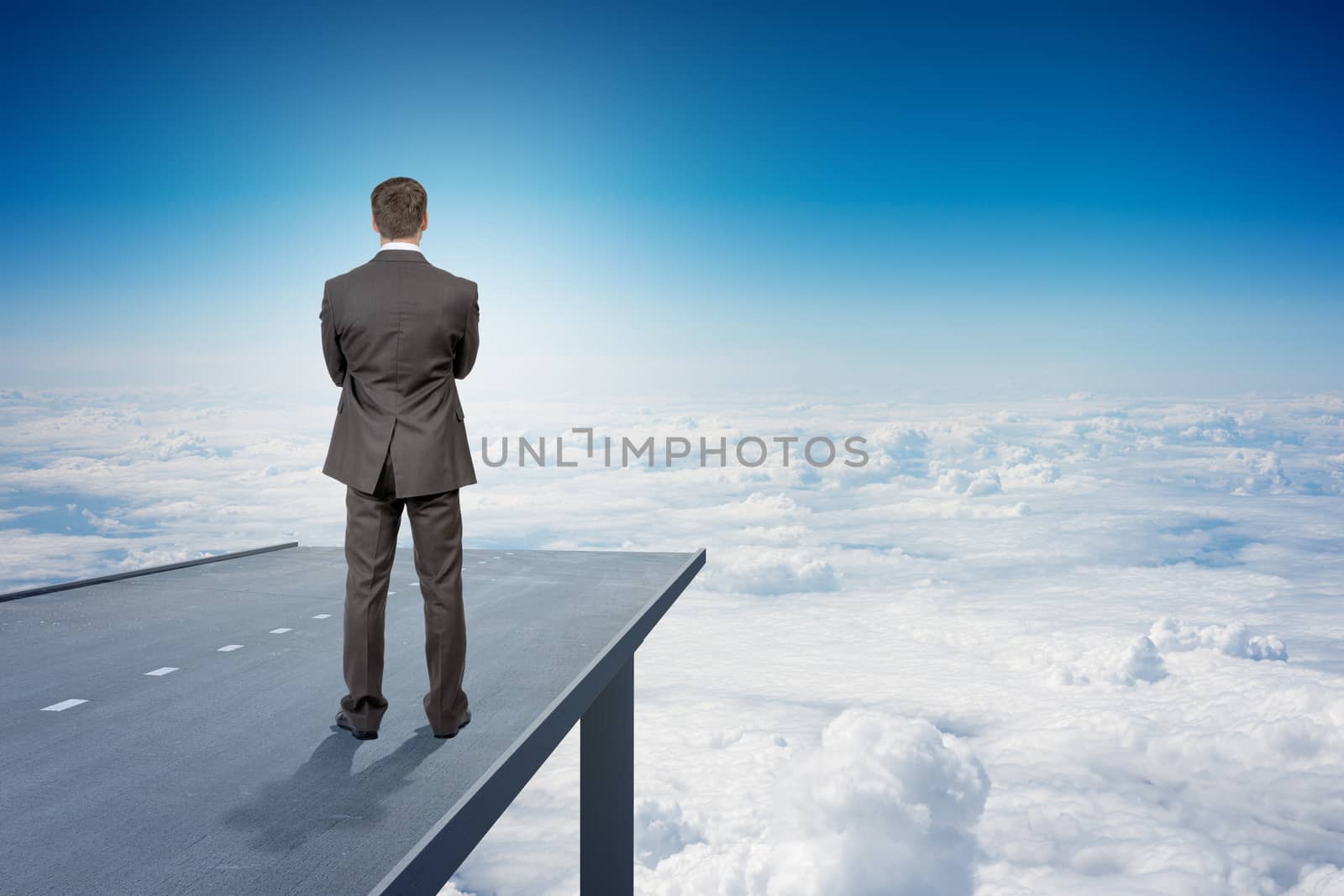 Businessman on road in sky, rear view by cherezoff