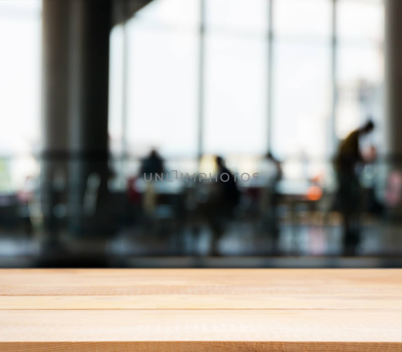 Wooden board empty table in front of blurred background. Perspective light wood table over blur silhouettes of people sitting in a cafe.. Mock up for display or montage your product.