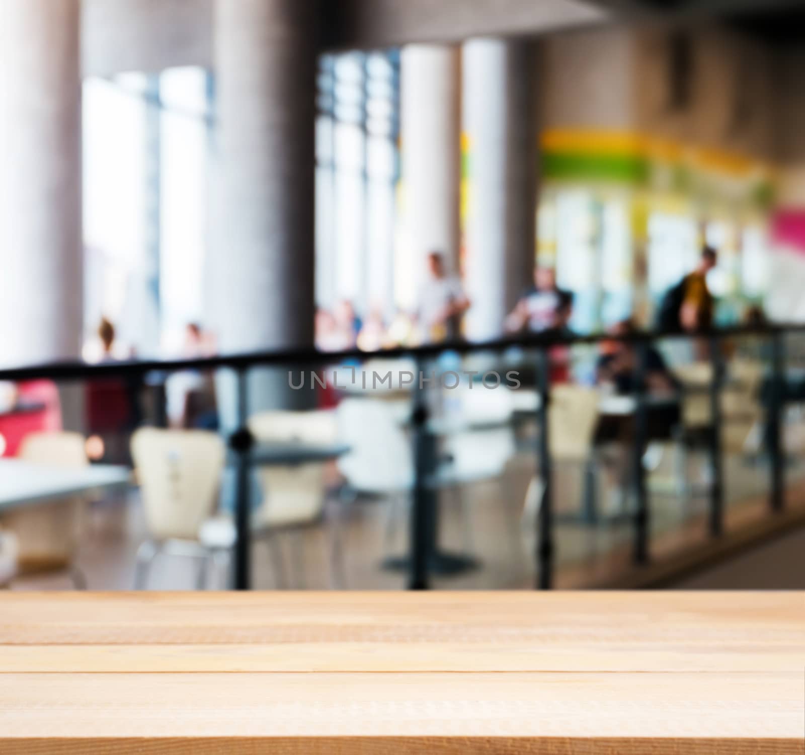 Wooden board empty table in front of blurred background. Perspective light wood table over blur silhouettes of people sitting in a cafe.. Mock up for display or montage your product.