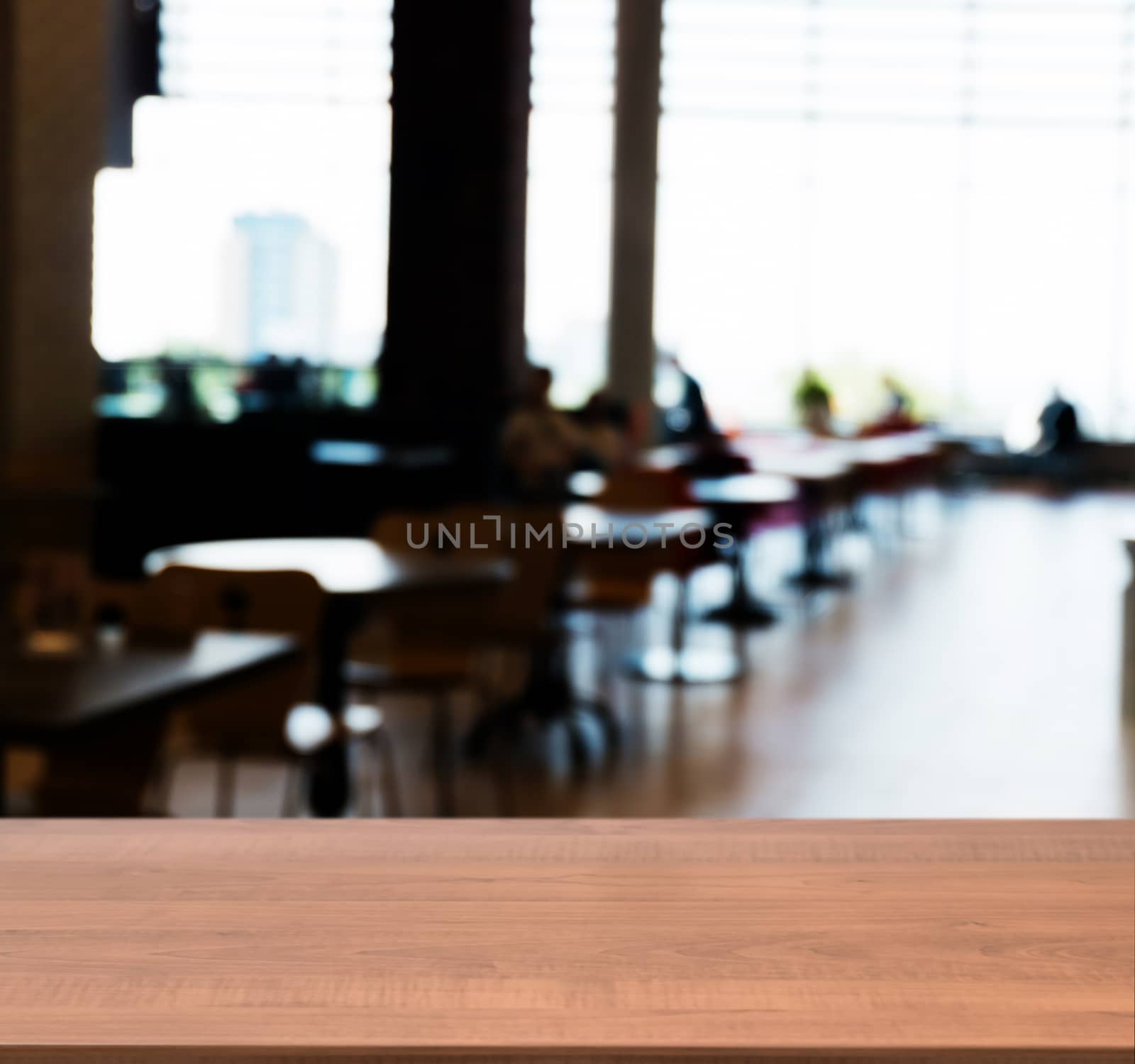 Wooden board empty table in front of blurred background. Perspective dark wood table over blur silhouettes of people sitting in a cafe.. Mock up for display or montage your product.
