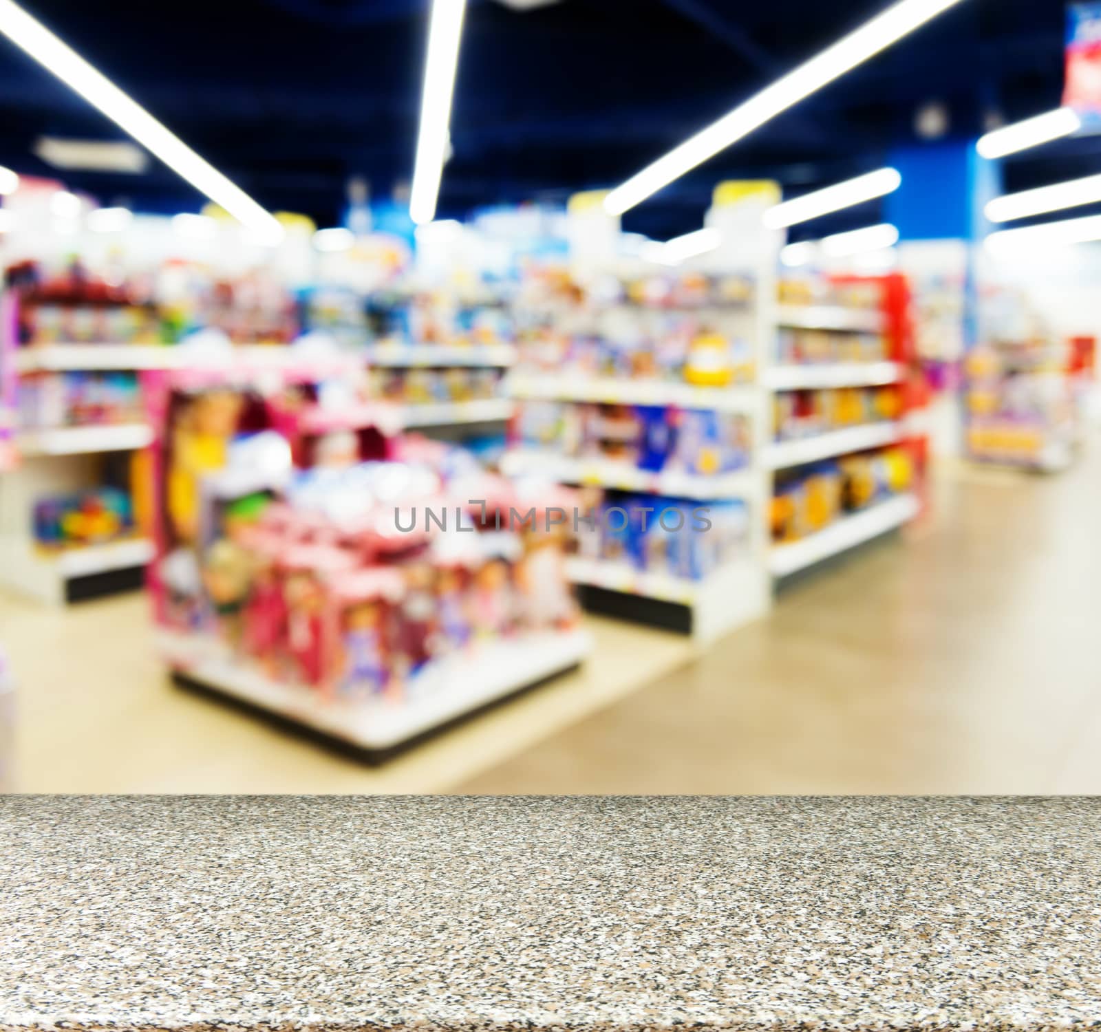 Marble board empty table in front of blurred background. Perspective marble table over blur in kids toy store. Mock up for display or montage your product.