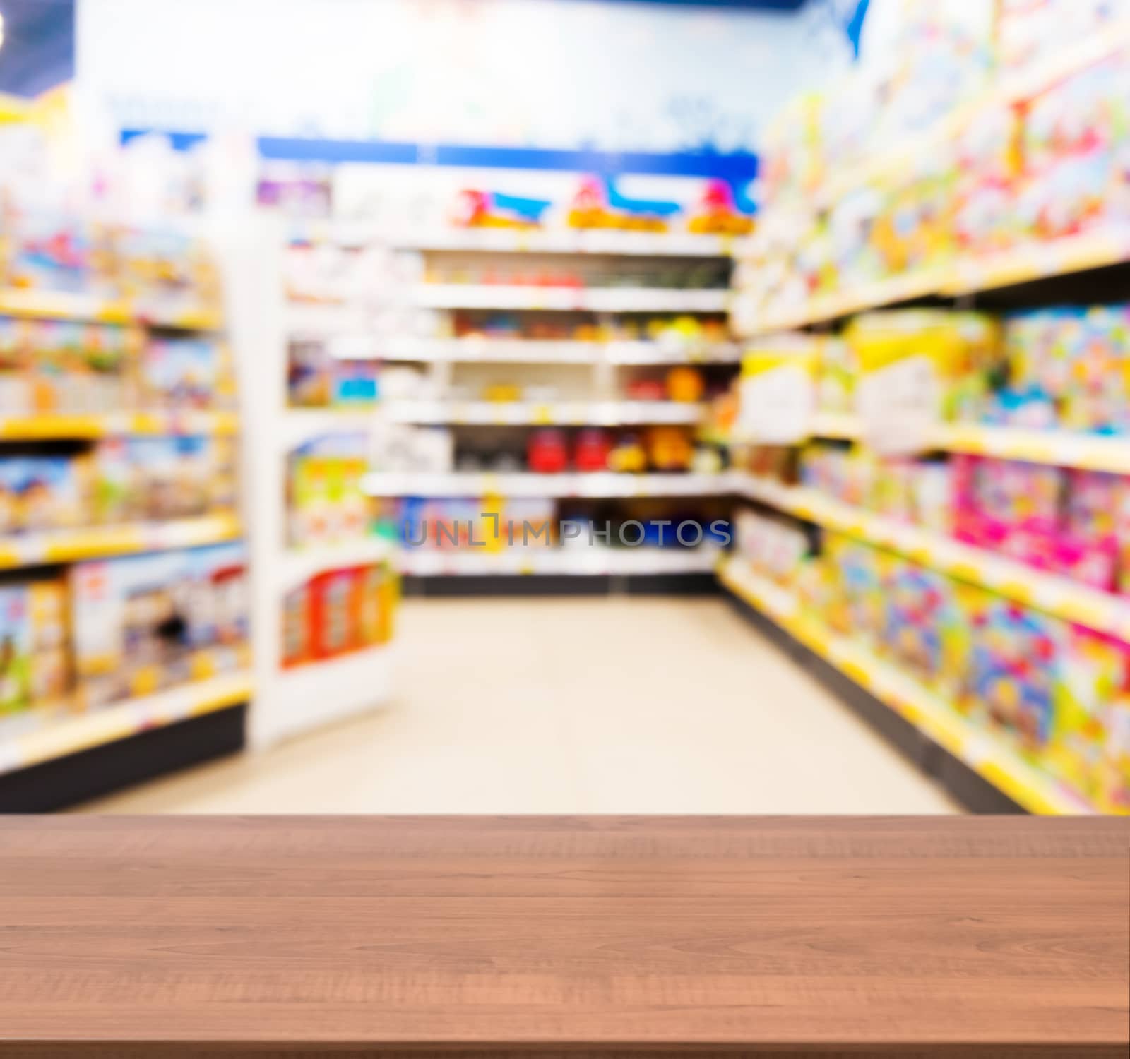 Wooden board empty table in front of blurred background. Perspective dark wood table over blur in kids toy store. Mock up for display or montage your product.