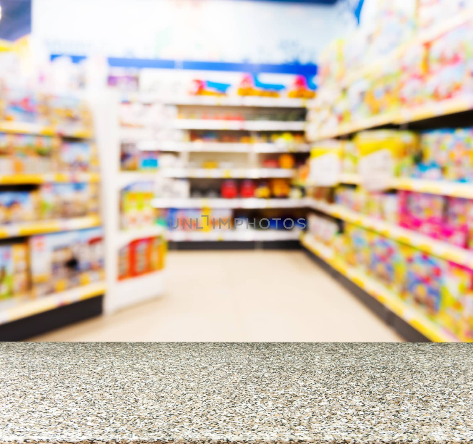 Marble board empty table in front of blurred background. Perspective marble table over blur in kids toy store. Mock up for display or montage your product.