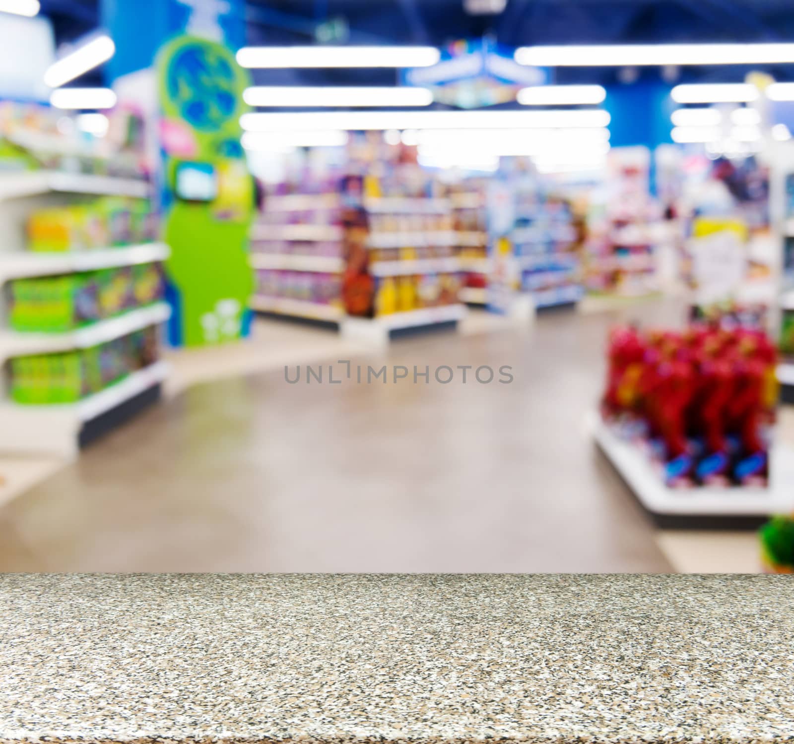 Marble board empty table in front of blurred background. Perspective marble table over blur in kids toy store. Mock up for display or montage your product.