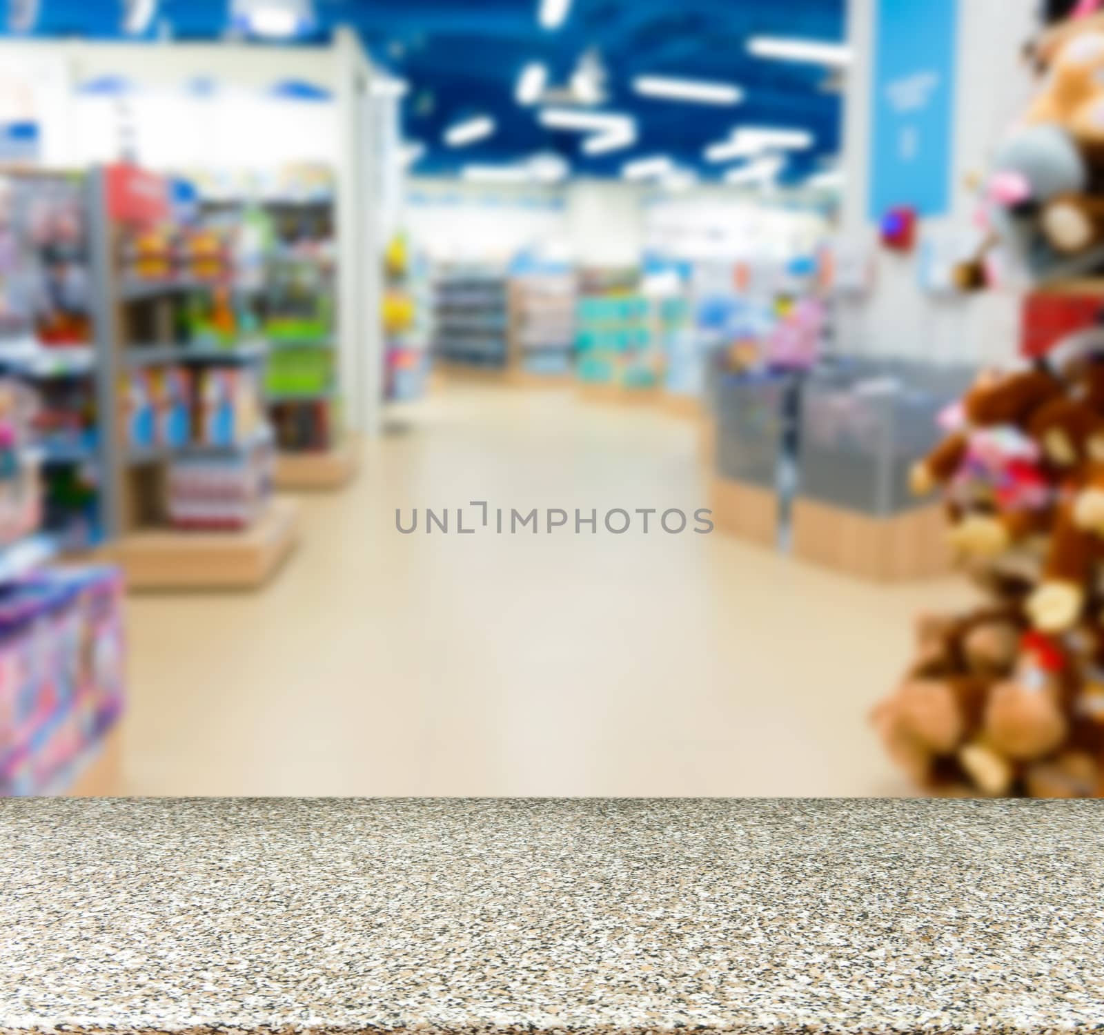 Marble board empty table in front of blurred background. Perspective marble table over blur in kids toy store. Mock up for display or montage your product.