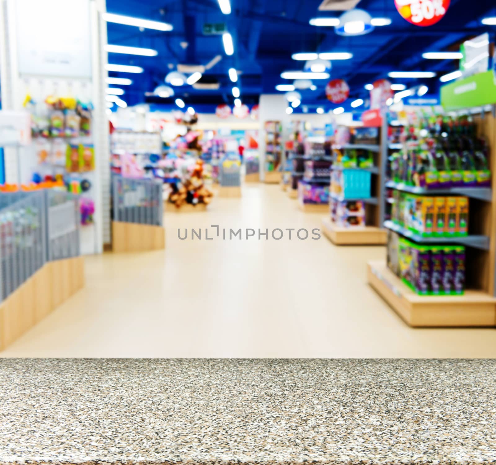 Marble board empty table in front of blurred background. Perspective marble table over blur in kids toy store. Mock up for display or montage your product.