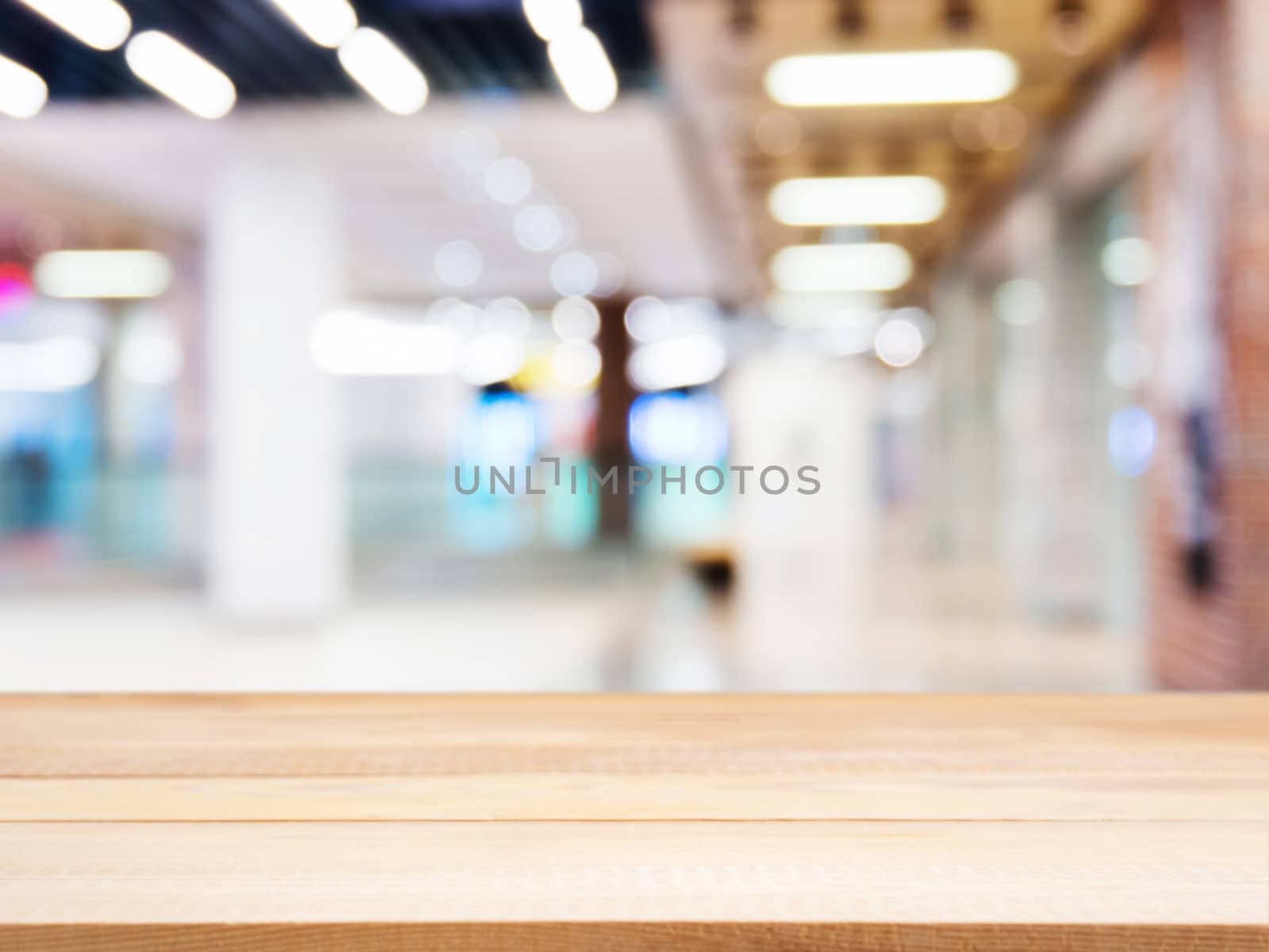 Wooden empty table in front of blurred mall by fascinadora