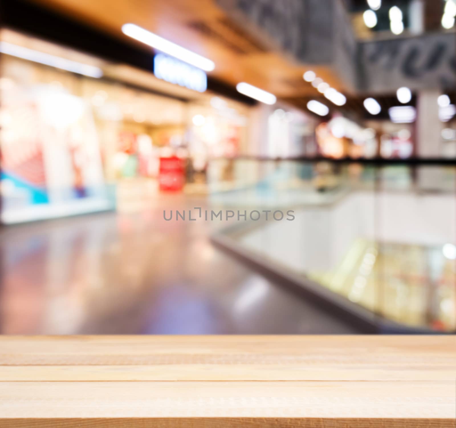 Wooden empty table in front of blurred mall by fascinadora