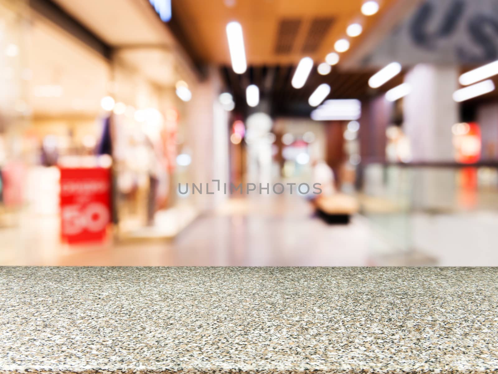 Marble board empty table in front of blurred background. Perspective marble table over blur in shopping mall hall. Mock up for display or montage your product.
