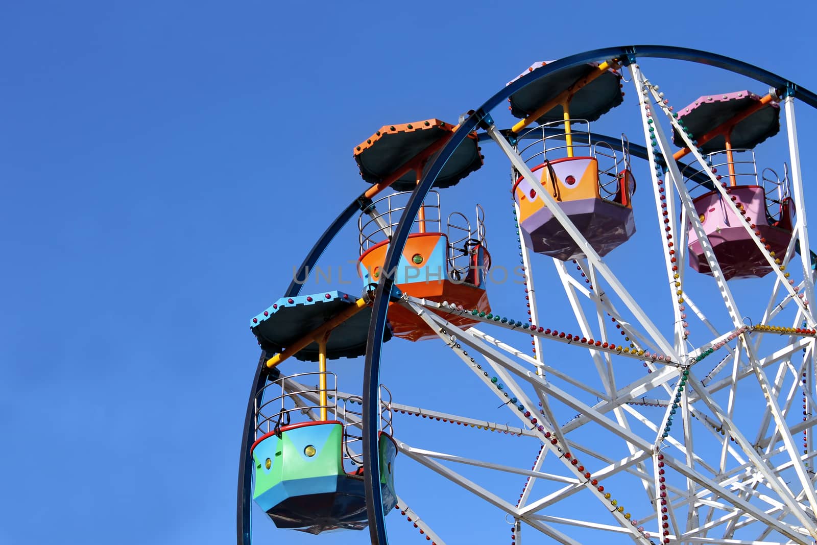 Colorful ferris wheel ride with blue sky background and copy space.