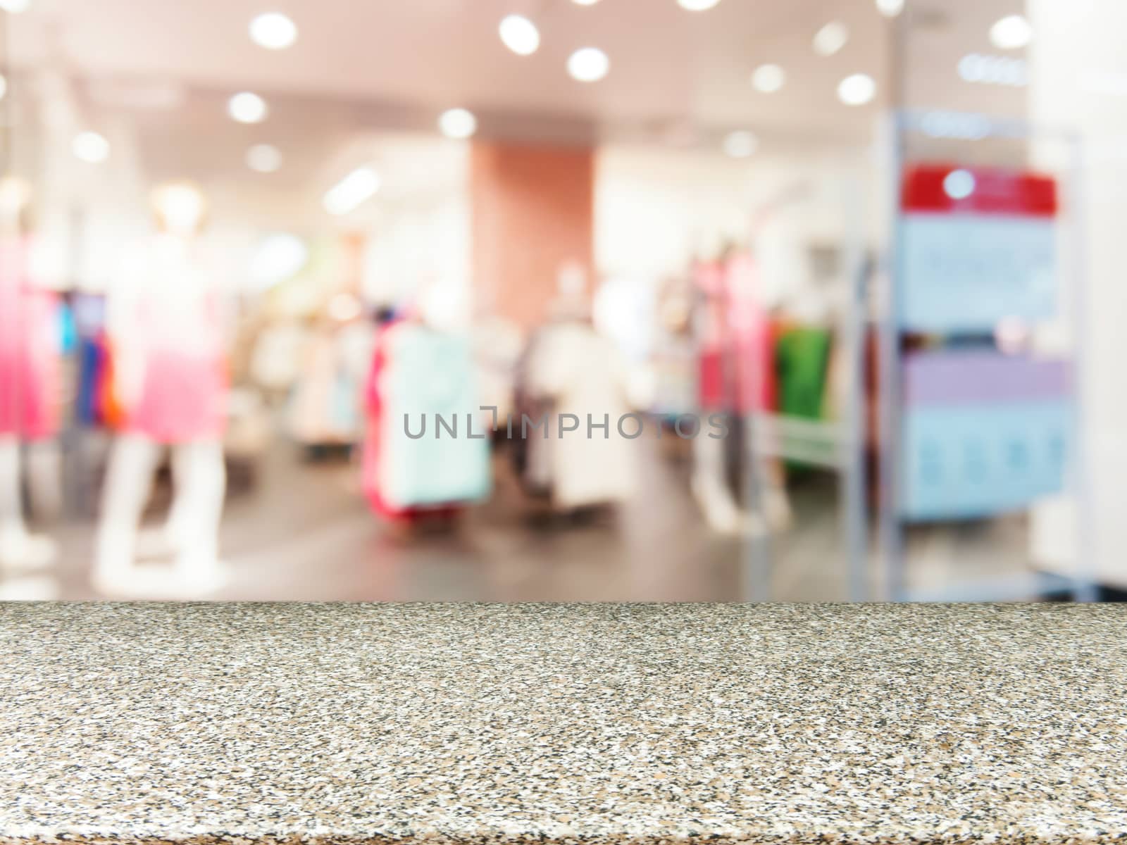 Marble board empty table in front of blurred background. Perspective marble table over blur in dress store. Mock up for display or montage your product.