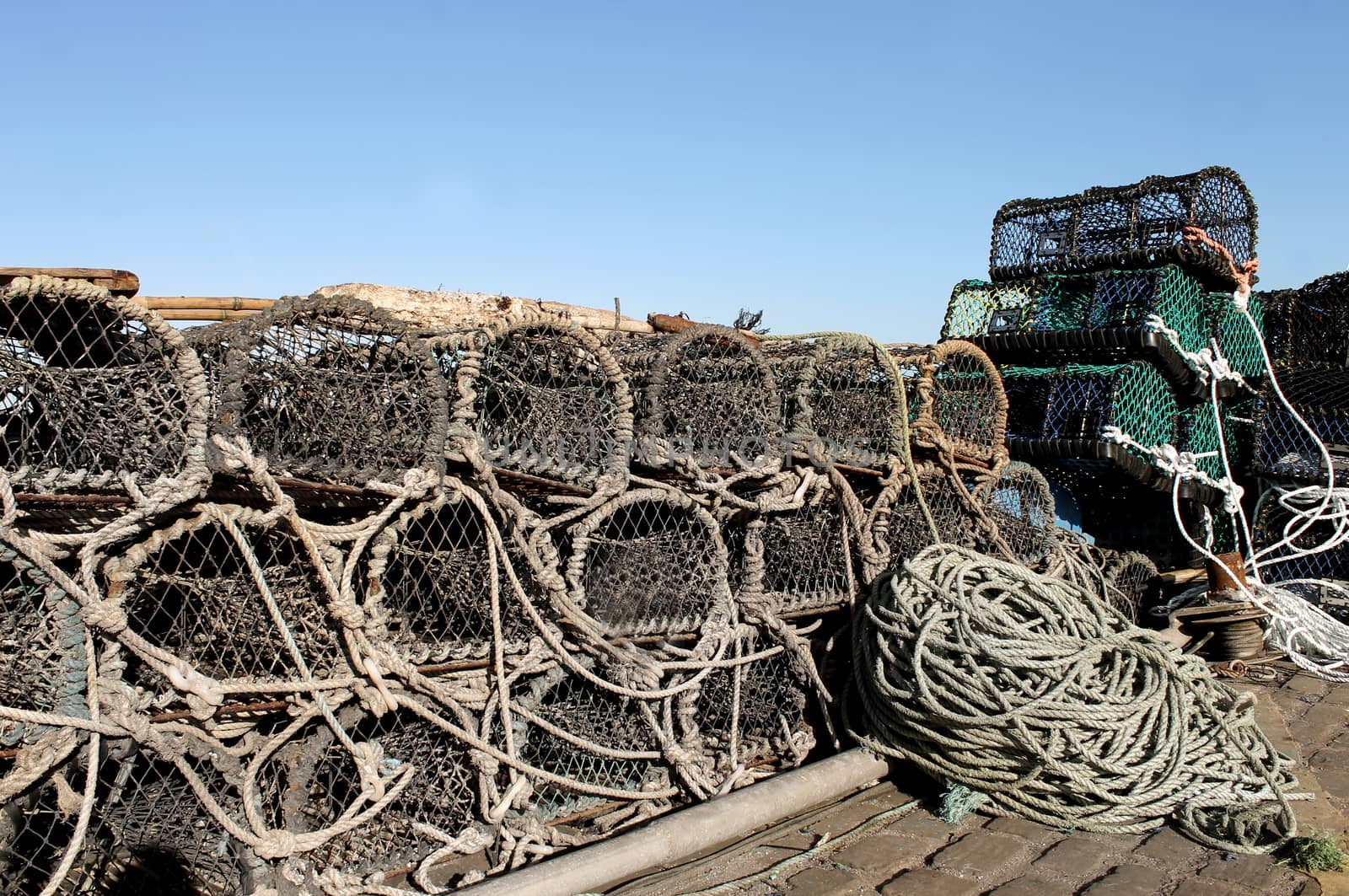 Lobster pots and fishing nets on a harbor quayside.